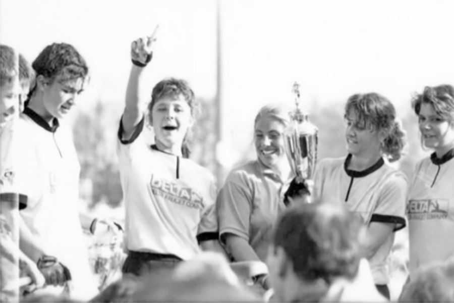 Group of women in athletic gear hold trophy and celebrate their team's victory at the first women's Little 500 race in 1988