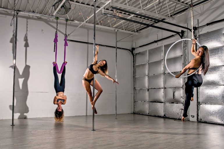 Anita DeCastro (center), BA’09, MA’14, owner of Wild Orchid Aerial Fitness and Dance, with Virginia Hojas (left) and Grace Wang (right) demonstrate aerial arts. Photo by Marc Lebryk.