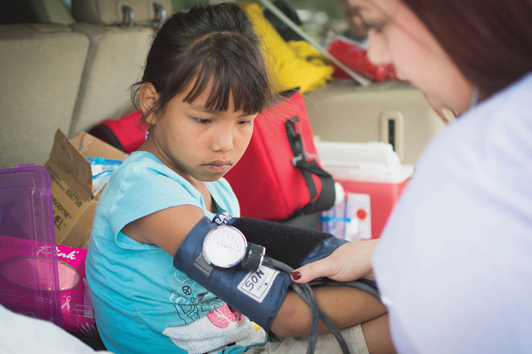 A nursing student tests a child's blood pressure at Pine Ridge.