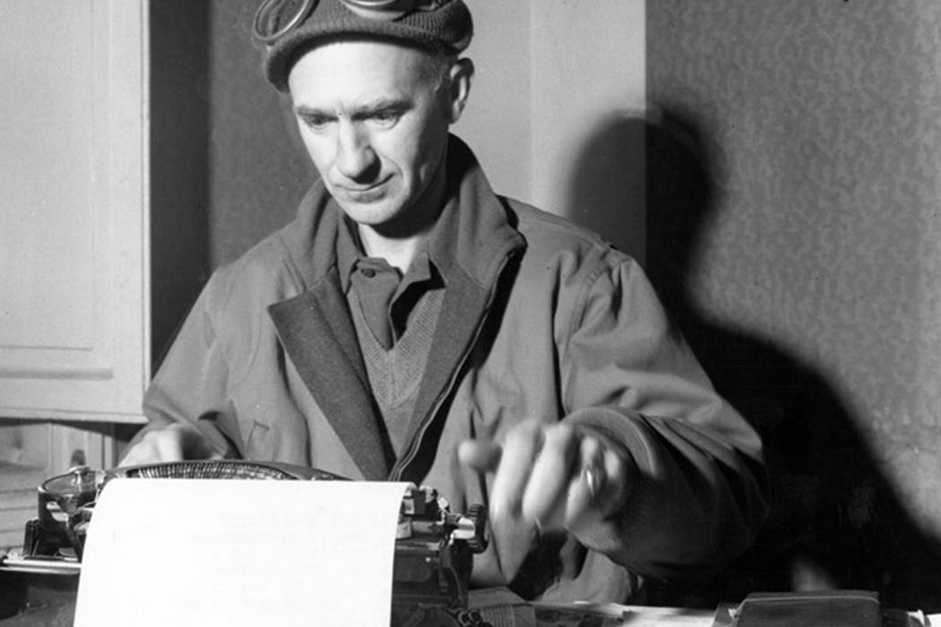 Black-and-white photo of Ernie Pyle writing at his typewriter.