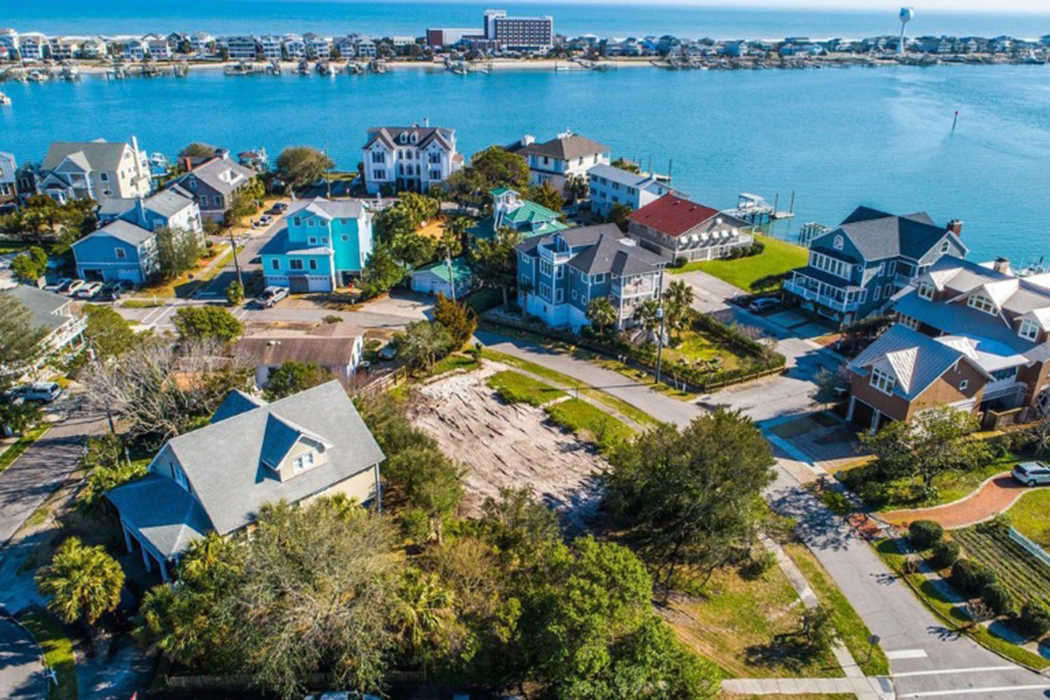 An overhead shot of several large houses next to a harbor. 