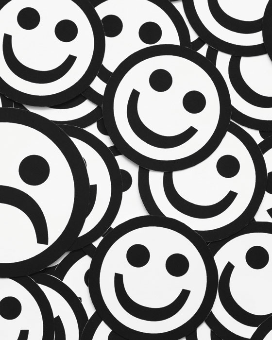 Black and white smiley faces appear as if they're lying in an enormous pile on top of each other.