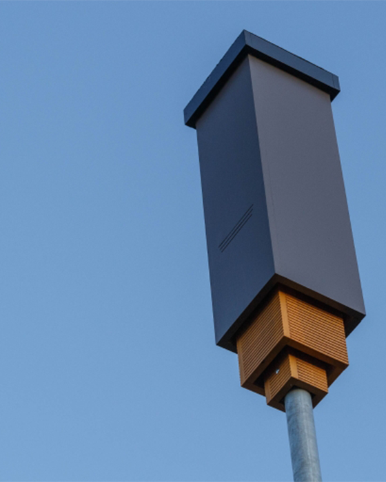 A tall, dark gray box affixed to a metal pole