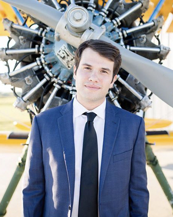 Caleb Blackerby stands in front of small airplane propeller