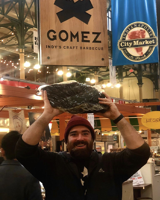 Michael Gomez holds huge chunk of meat above his head 