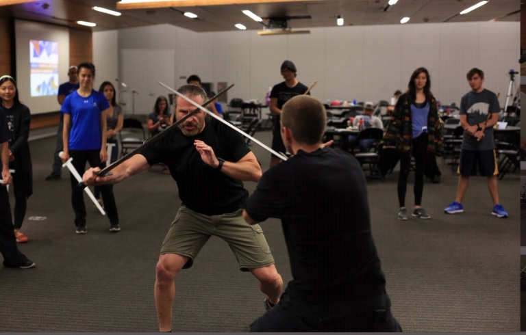 Patrick Kelly crosses swords with a student in class
