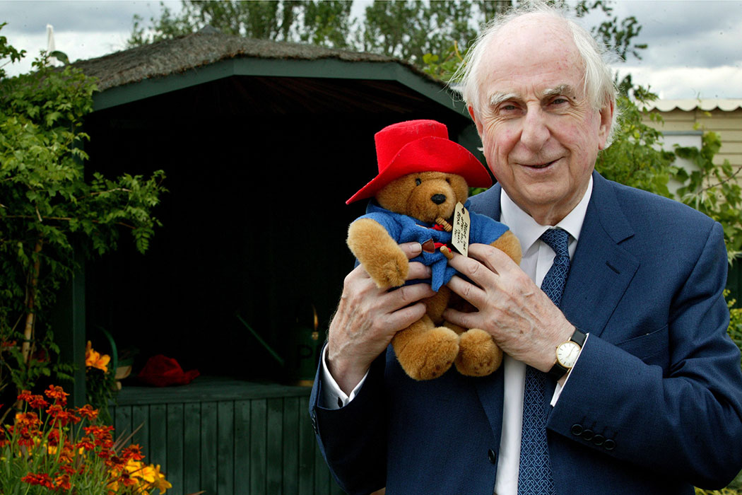Michael Bond holding a Paddington Bear stuffed animal