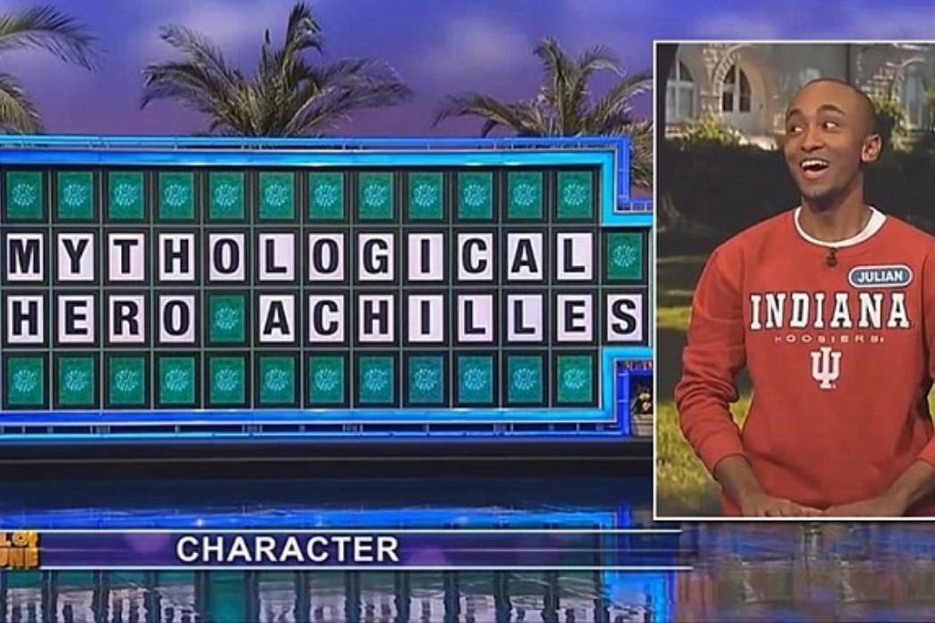 Man next to a game board that reads "MYTHOLOGICAL HERO ACHILLES"