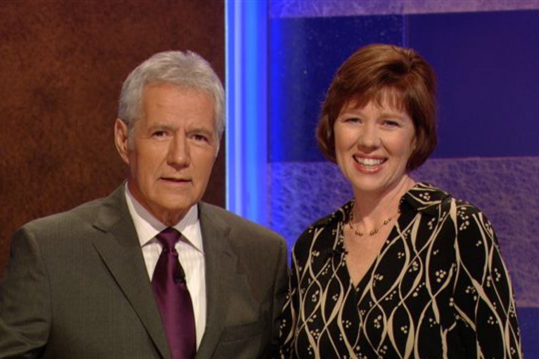 Woman and man smiling on a game show set.