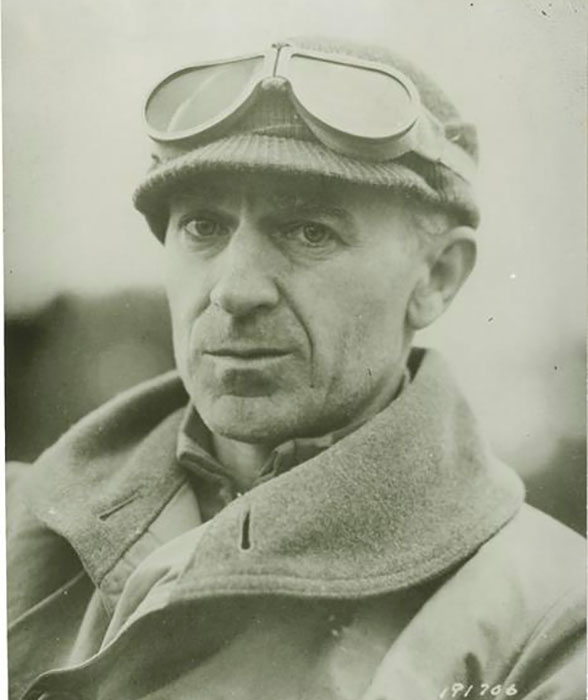 Journalist Ernie Pyle stands in aviation gear as the photographer snaps a candid photo.