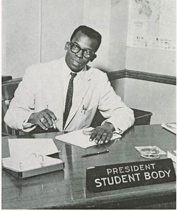 IU alum and first Black student body president, Thomas Irving Atkins, sits at his desk, writing on a notepad.