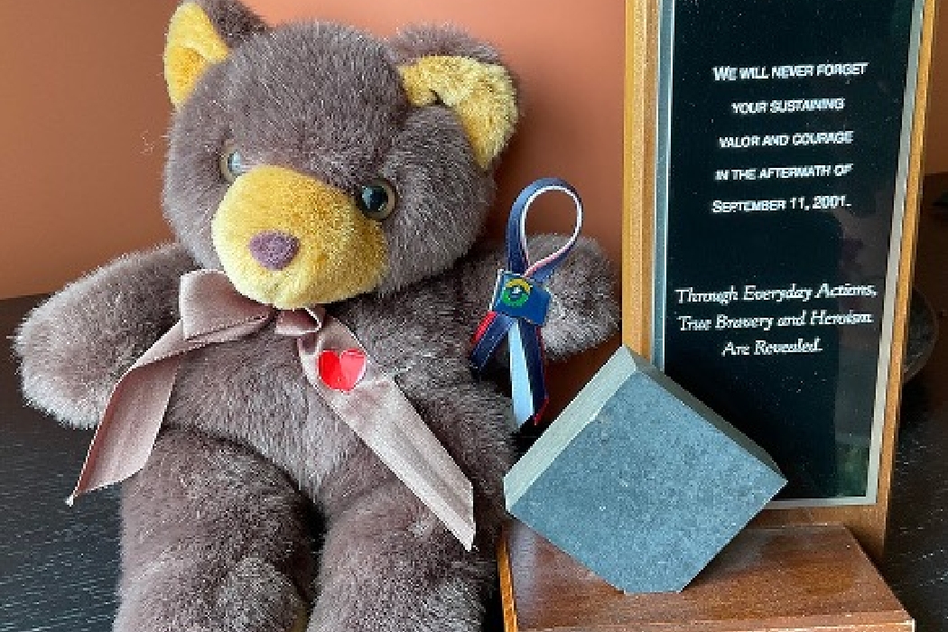 Teddy bear and a plaque holding a chunk of steel from the World Trade Center