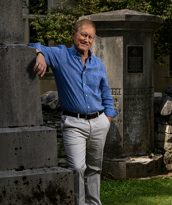 Stephen Hofer standing next to tombstones in Dunn Cemetery