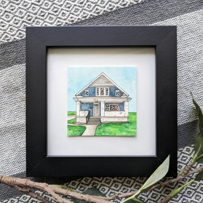 A framed watercolor of a house